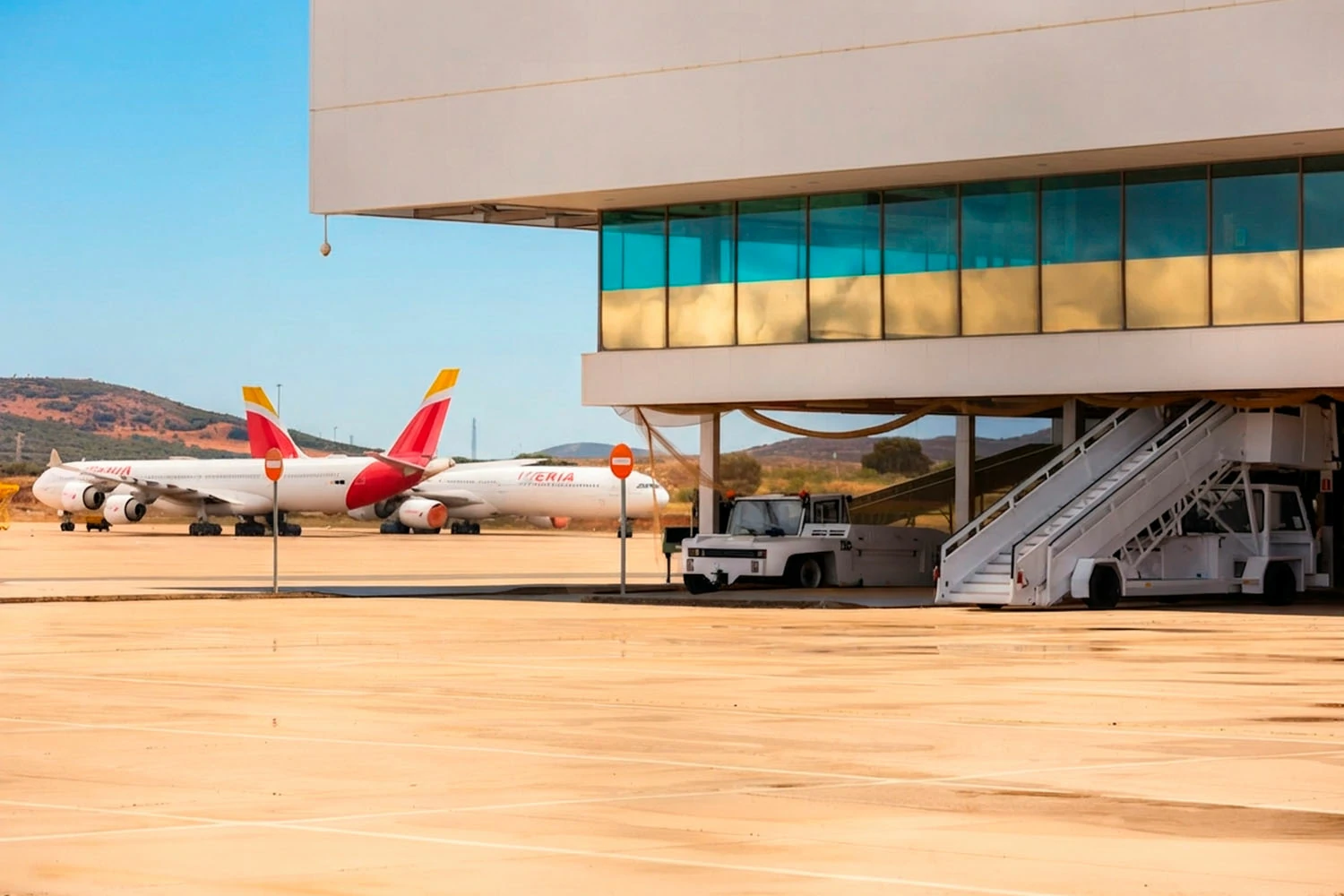 Vista panorámica de la plataforma del Aeropuerto de Ciudad Real (CRIA) mostrando parte de la terminal y aviones comerciales estacionados.